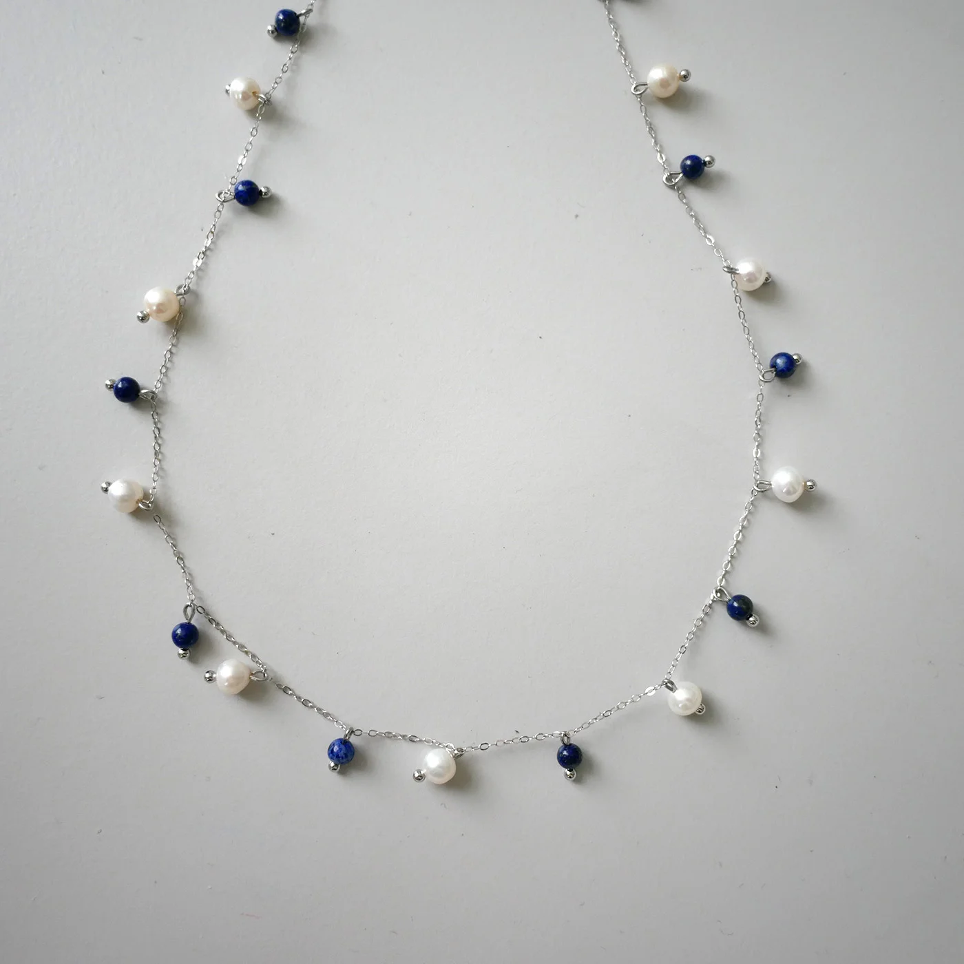 Eterisk Perlekaskade — Lapis Lazuli, Sødvannsperle, Sterling sølv 925 — håndlagde perlekjede med ferskvannsperler fra Ollie Pearls Bergen, Norge